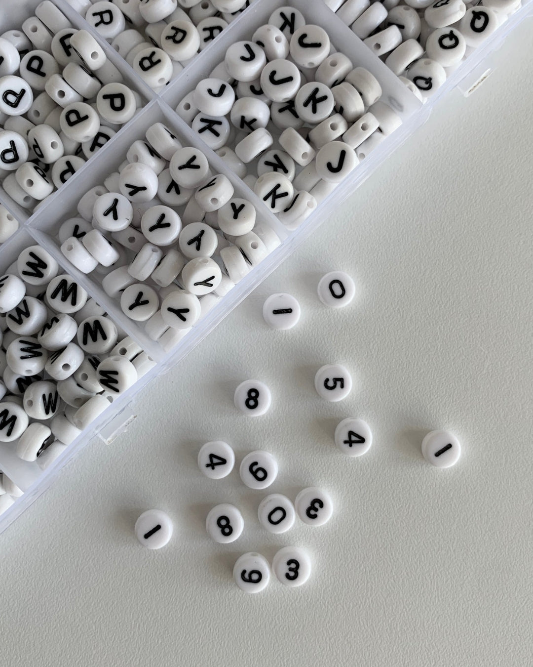 Assorted white and black alphabet beads to choose from when creating a Buttercup Studio Custom Freshwater Pearls Necklace.