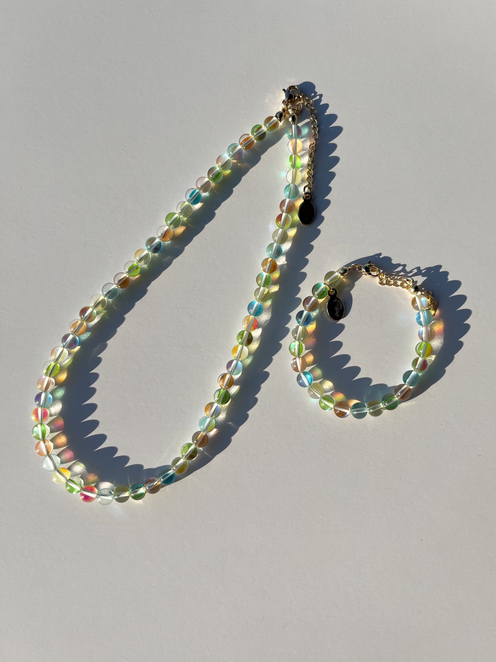A studio shot of Buttercup Studio's Tropical Bubbly Bubbles Bracelet next to the Tropical Bubbly Bubbles Necklace.