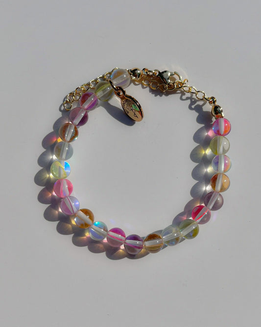 A studio shot of the Confetti Bubbly Bubbles Bracelet by Buttercup Studio. Handmade using assorted colour glass beads. Made with an adjustable chain, 14k gold clasps and a Buttercup Studio emblem.