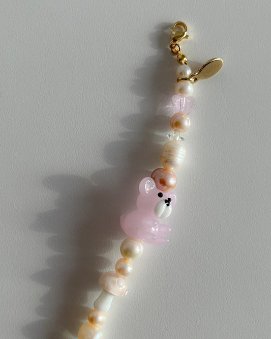 A close up studio shot of Buttercup Studio's Honey Bear Freshwater Pearls Bracelet. Made with assorted freshwater pearls, clear pink beads, a special pink mushroom lampwork glass bead and a special pink teddy lampwork glass bead.