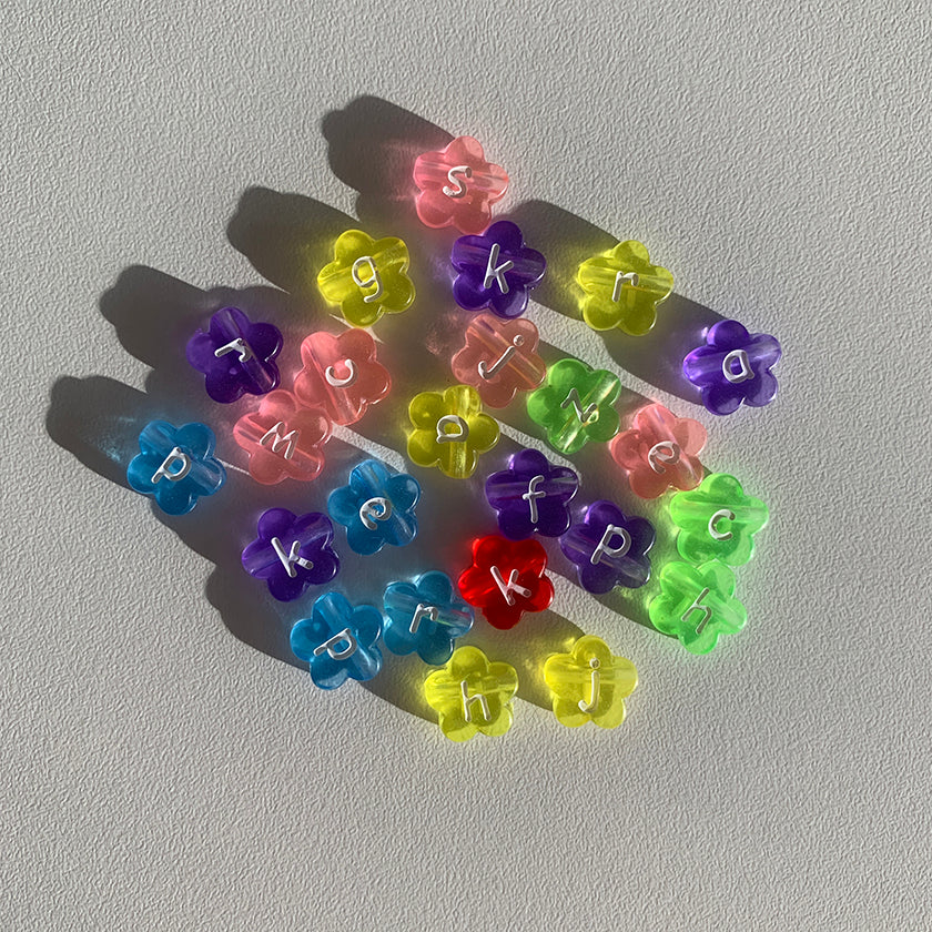 Assorted colourful flower shaped alphabet beads to choose from when creating a Buttercup Studio Custom Regular Pearls Necklace.