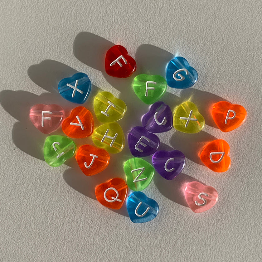 Assorted colourful heart shaped alphabet beads to choose from when creating a Buttercup Studio Custom Regular Pearls Necklace.