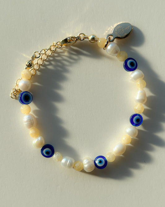 Studio shot of Buttercup Studio's Evil Eye Freshwater Pearls Bracelet. Made with special lampwork glass evil eye beads and assorted freshwater pearls.