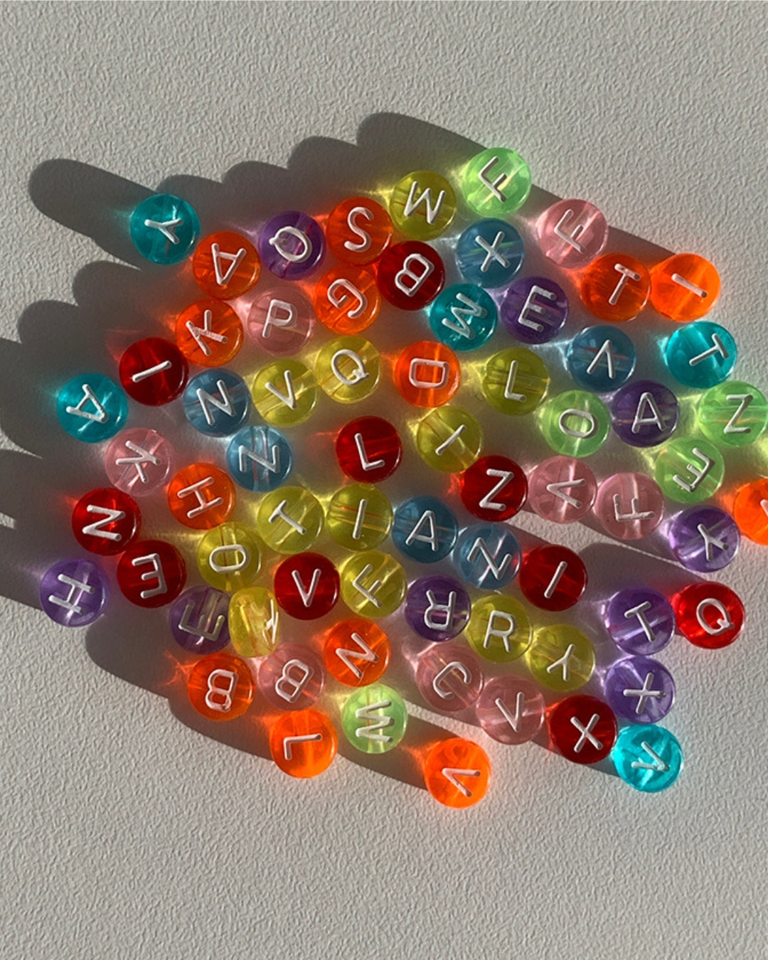 Assorted colourful alphabet beads to choose from when creating a Buttercup Studio Custom Multipurpose Strap.