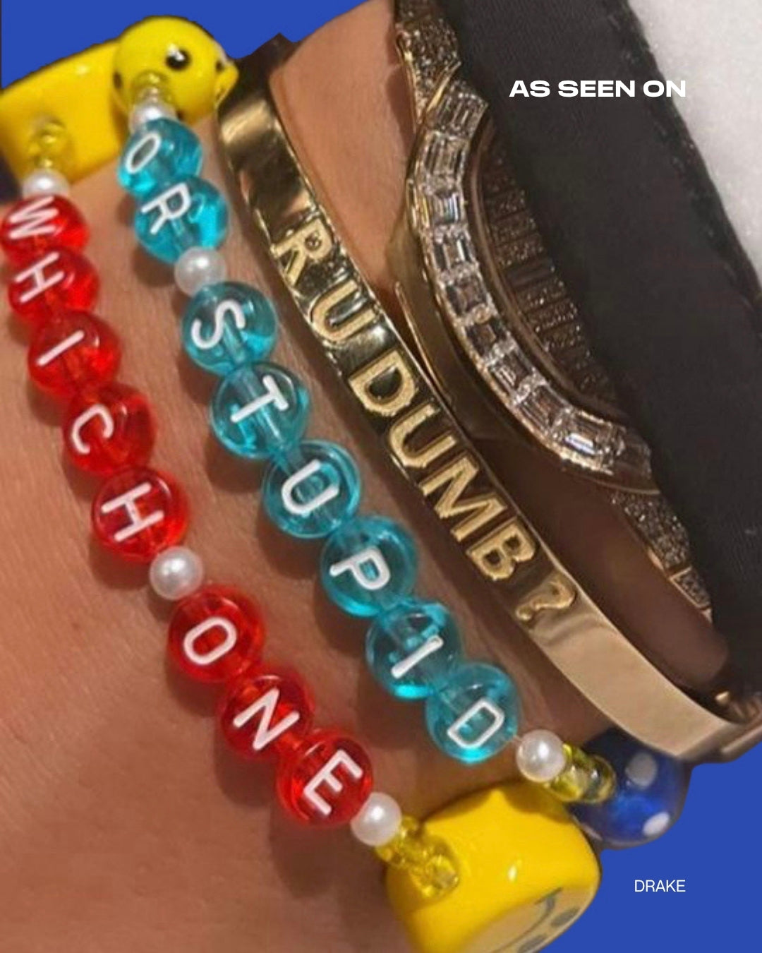 A close up of Buttercup Studio's Aubrey Set on Drake's wrist. A gold curved bracelet band carved with the phrase R U DUMB? with the Drake Custom Bracelet set in orange beads spelling out R U DUMB? below it, and a Drake custom bracelet set in teal beads spelling out OR STUPID below that, and a Drake Custom Bracelet in red beads spelling out WHICH ONE under it, and a Drake Custom Bracelet set in purple beads spelling out YA FREAK at the bottom. Image credits: @champagnepapi on Instagram.