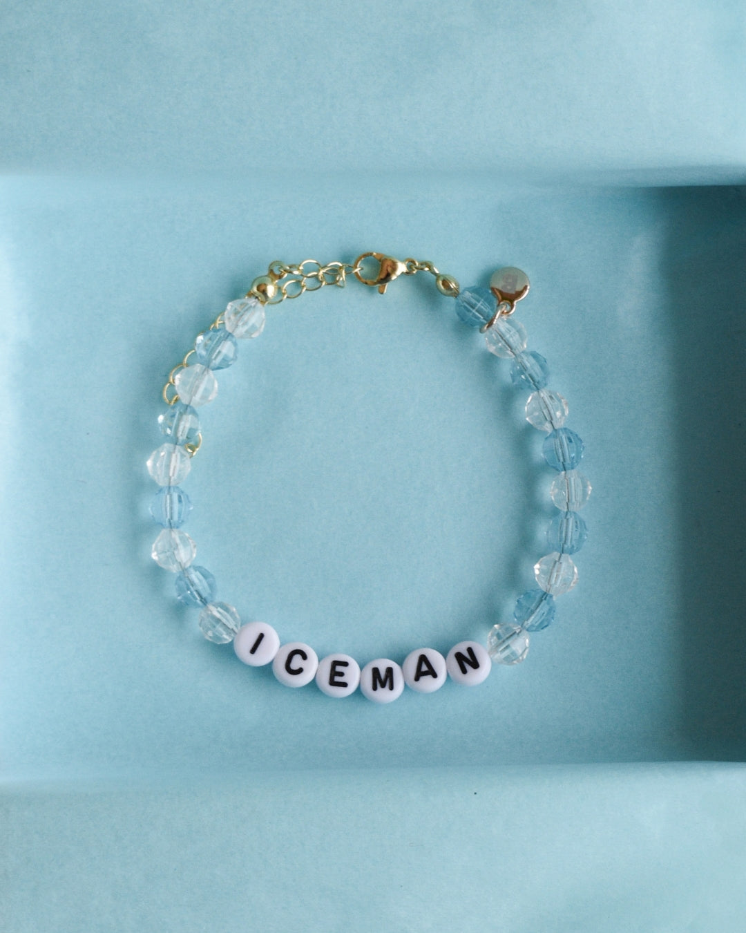 Drake Bracelet with 'ICEMAN' beads in a light blue jewelry box on a beige background