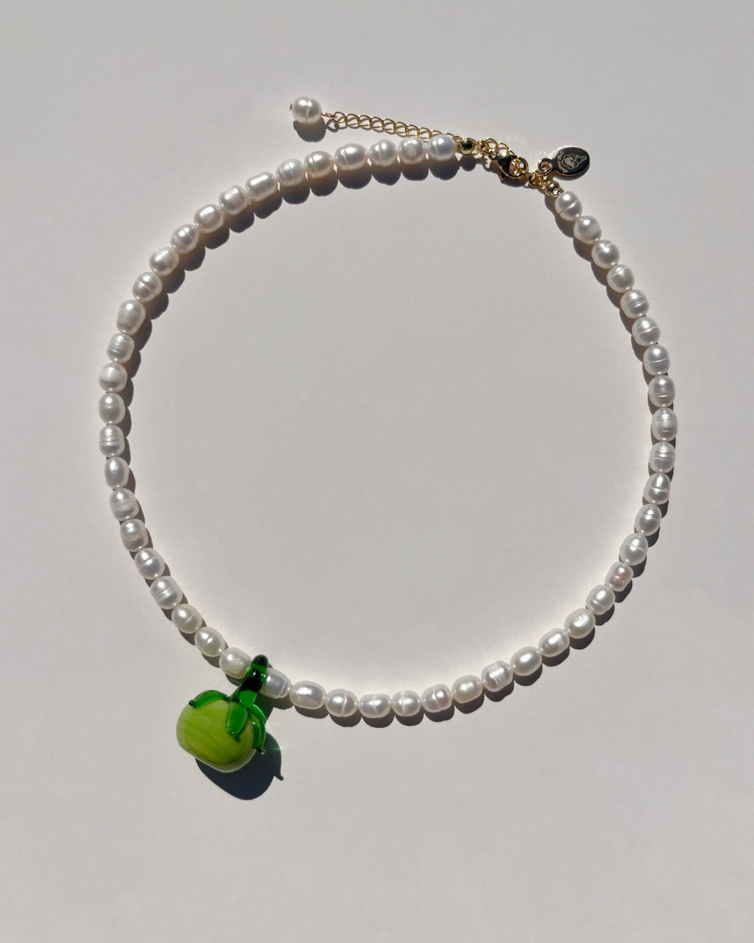 Picture yourself strolling through sun-drenched Italian streets, Aperol Spritz in hand, and indulging in plates of pasta, all while wearing The Heirloom Tomato Freshwater Pearl Necklace.&nbsp;This playful piece perfectly captures the essence of a carefree tomato girl summer, adding a touch of elegance and whimsy to your look as you embrace la dolce vita.
The Heirloom Tomato Freshwater Pearl Necklace is made using high-quality AA+ rare freshwater pearls and features&nbsp;handmade 35mm red tomato glass charms
