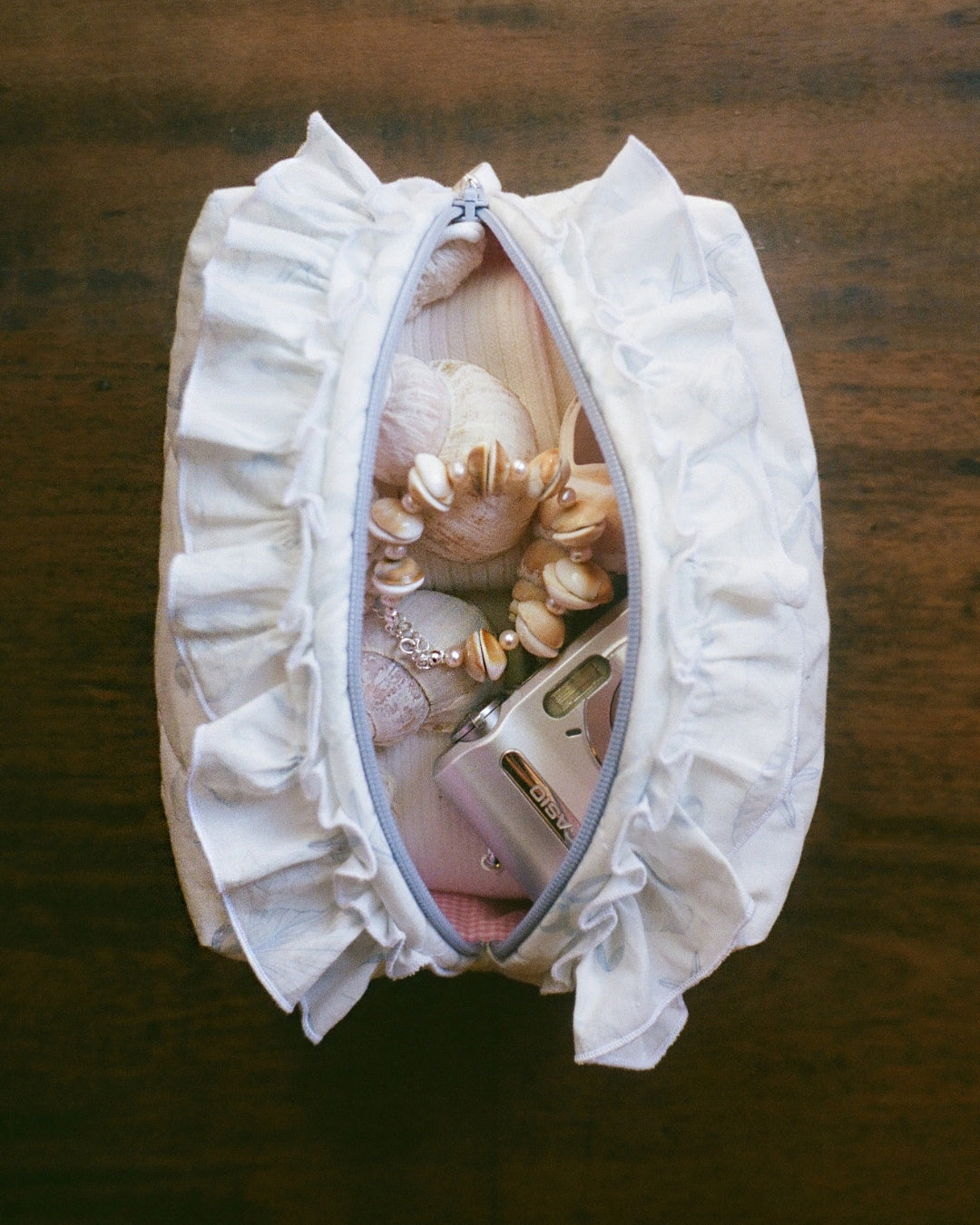 The Baguette x Buttercup Studio collaboration brings together the Limited Edition Ocean Spiral Ruffles Pouch and the Exclusive Sundial Oyster Freshwater Pearl Bracelet. This pairing combines Baguette’s signature ruffled silhouette in a custom print with Buttercup Studio’s refined freshwater pearl jewellery.&nbsp;