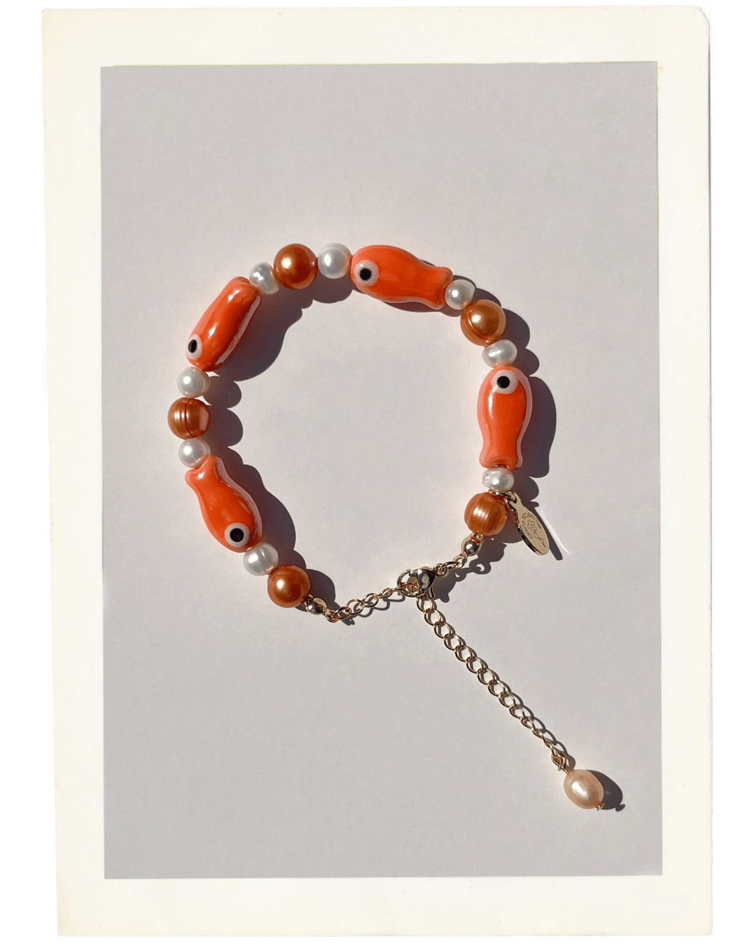 The Lucky Fish Freshwater Pearl bracelet in Creamsicle is made using high-quality AA+ rare copper hue freshwater pearls and glazed orange fish ceramic fish beads. 